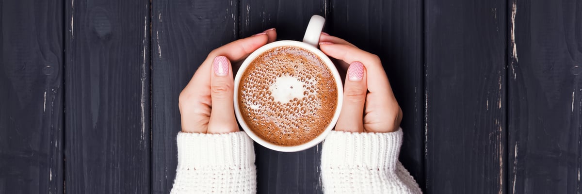 Hands holding a cup of coffee - Dairy and Ice cream - AAK