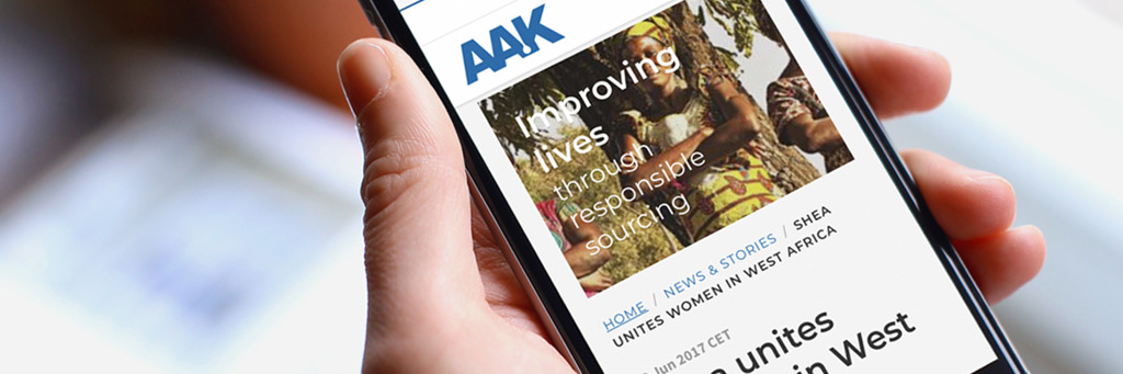 Hand holding a smart phone that displays AAK news article - News & Stories - AAK
