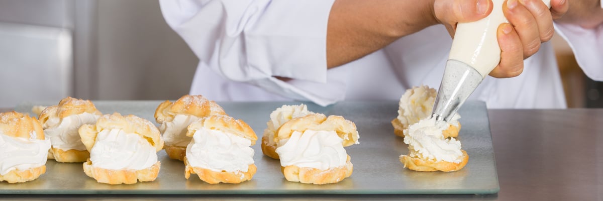 Baker piping cream on cakes - Dairy and Ice cream - AAK