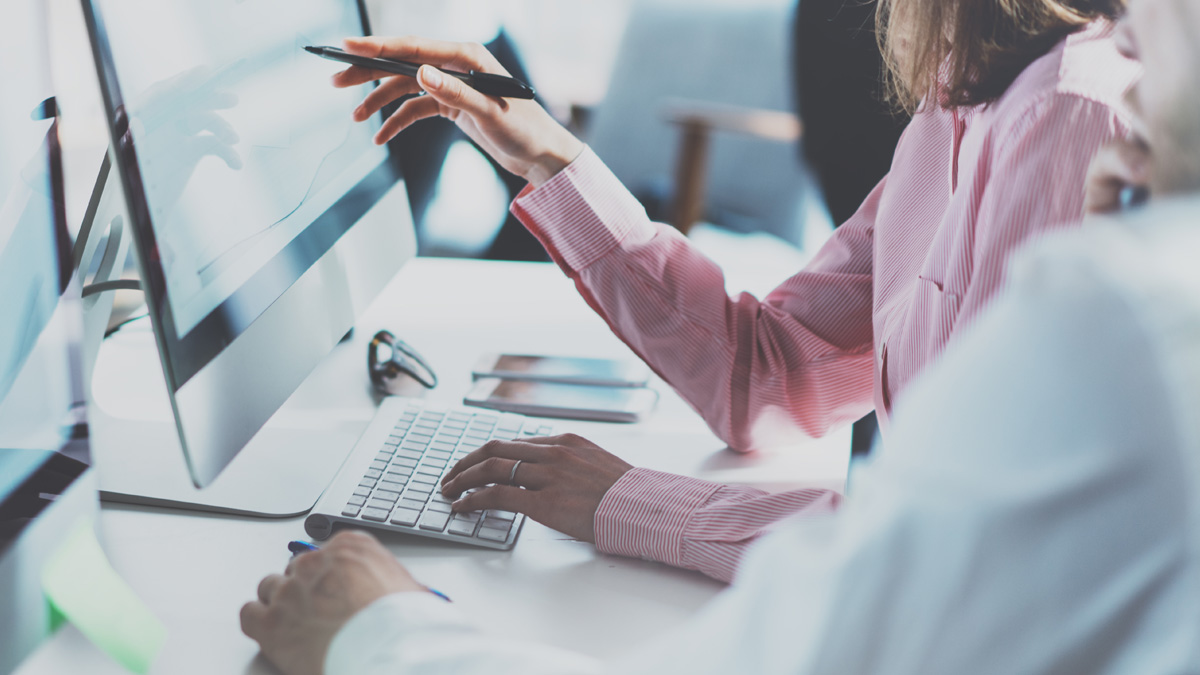 Co-Workers Pointing at Screen with Financial Information - Investors - AAK